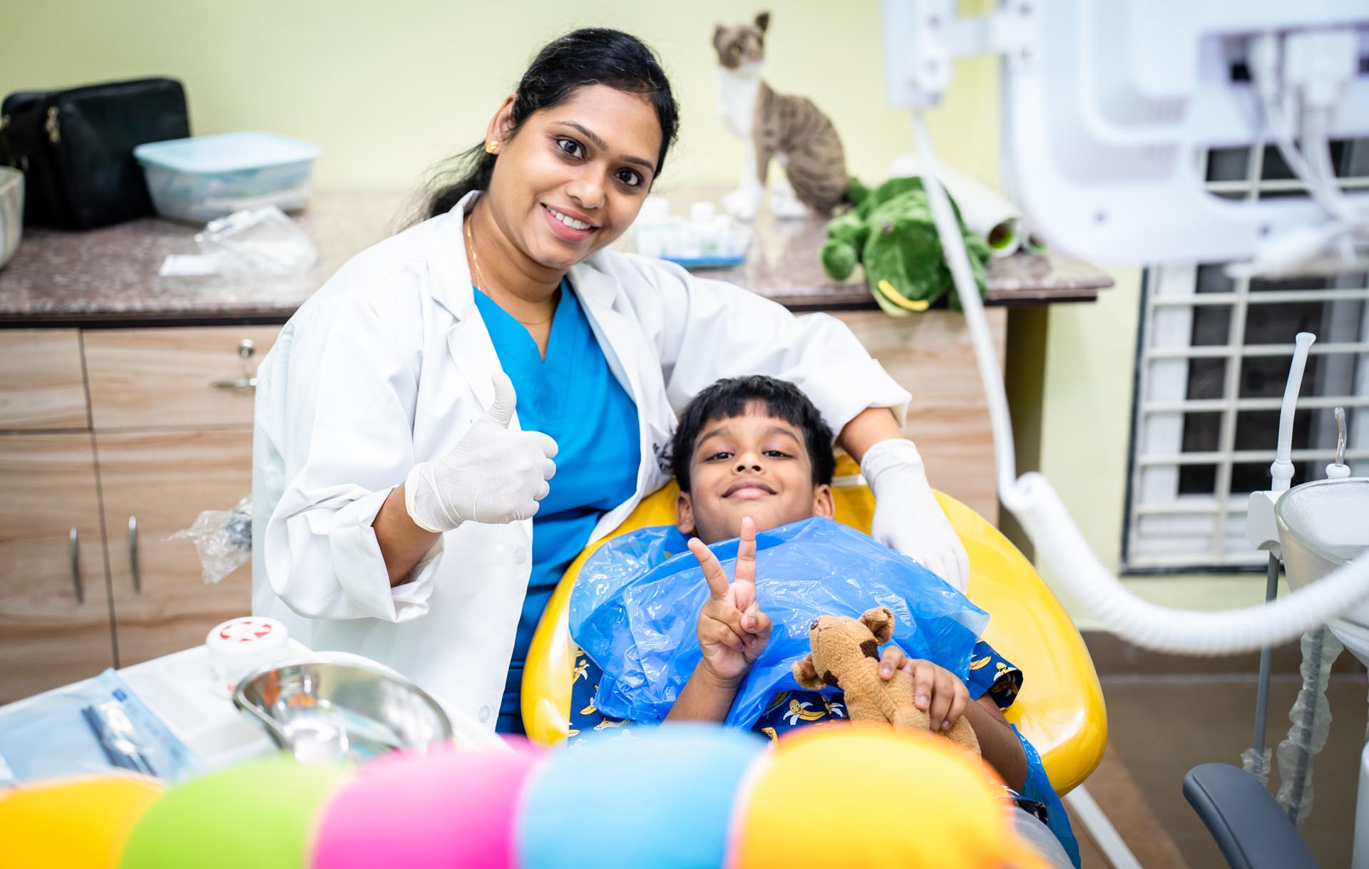 shows Dr.Sangeeta Teleti & her child patient ,both smiling & giving thumbs up